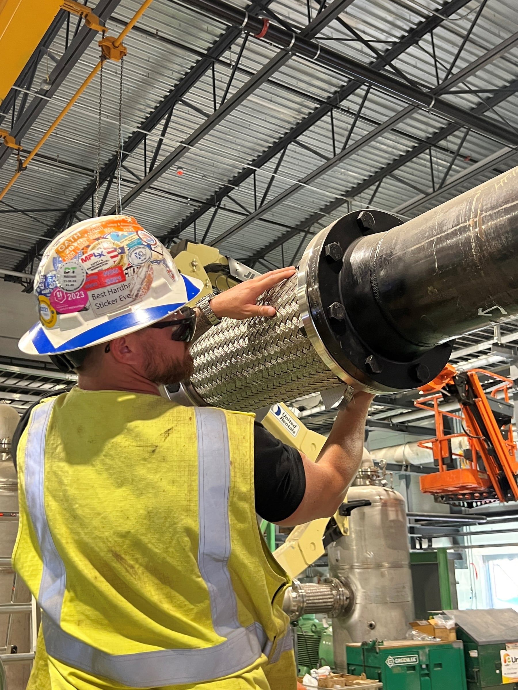 Crew member fitting a braided flex connection during test preparation