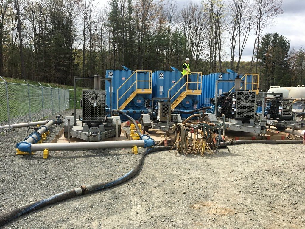 Crew member tending hose between pumping skids and station piping