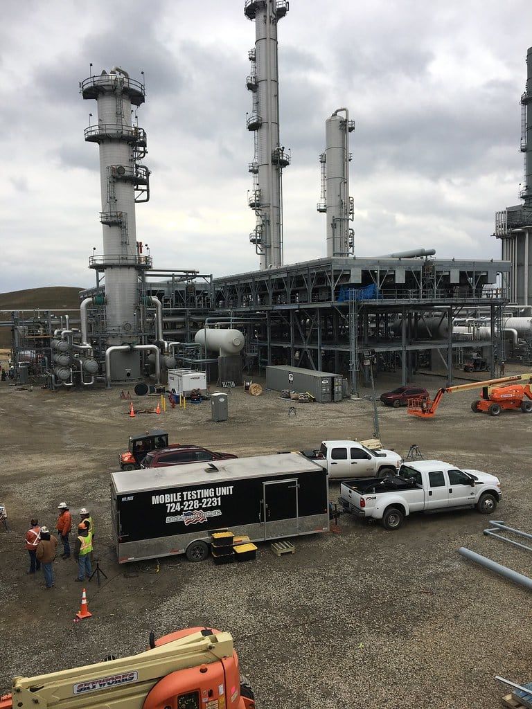 Mobile testing unit and crew trucks staged at a processing plant