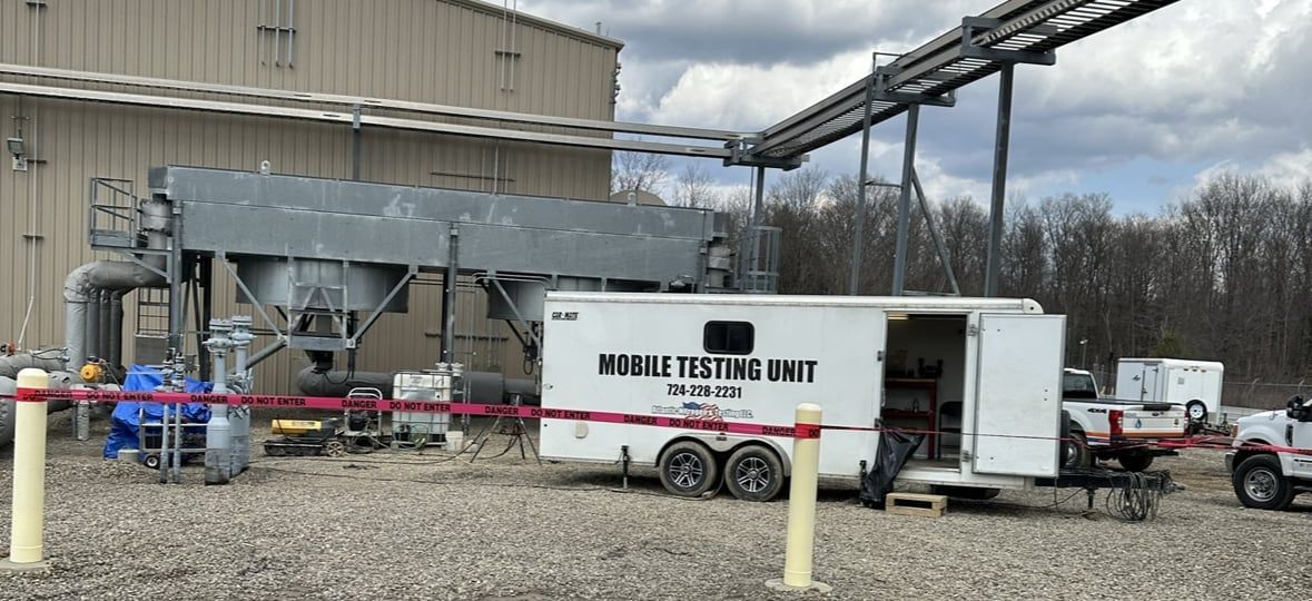 Mobile testing unit parked beside a plant building