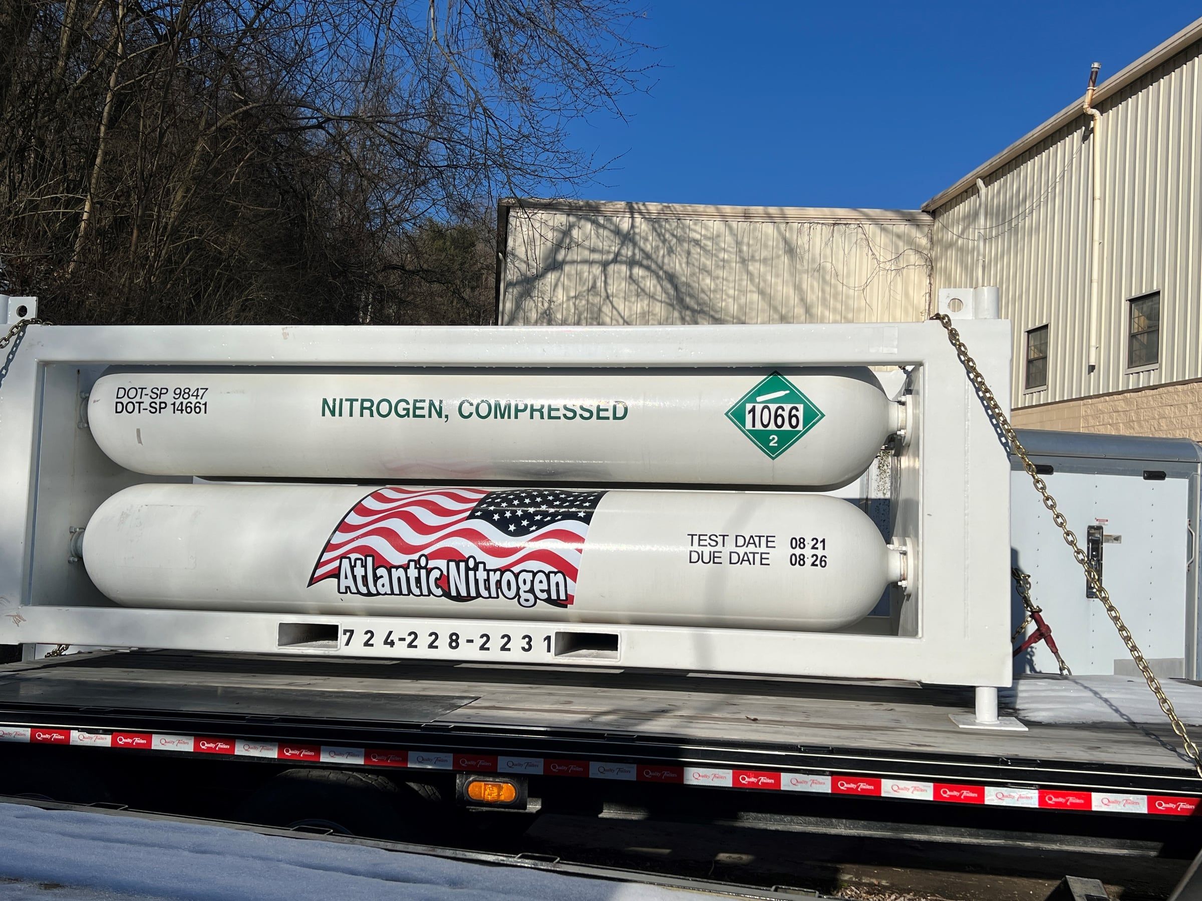 Compressed nitrogen tube module on a flatbed showing DOT special permit markings and test dates